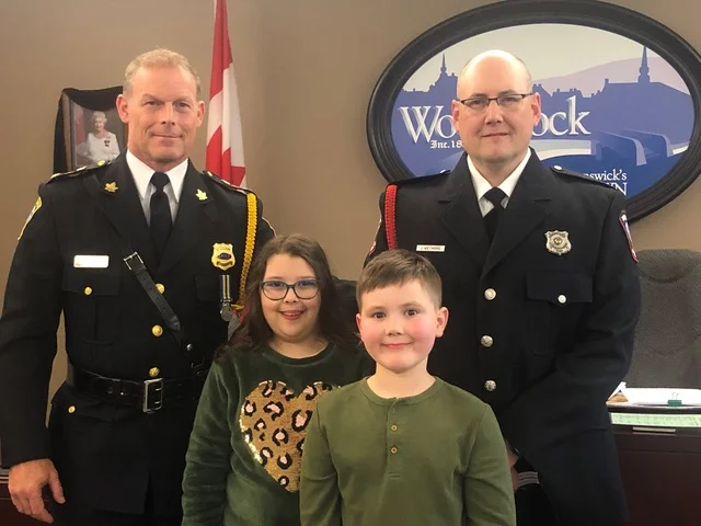 Woodstock Police Force Cpl. John Wetmore, right, is joined by children, Jocelyn, 11, and Malcolm, 7, and Chief Gary Forward, following his promotion ceremony in Woodstock council chambers, Oct. 11. Wetmore’s wife Kim, oldest son Nicholas and several members of the Woodstock Police Force were also on hand for the event. (Jim Dumville photo)