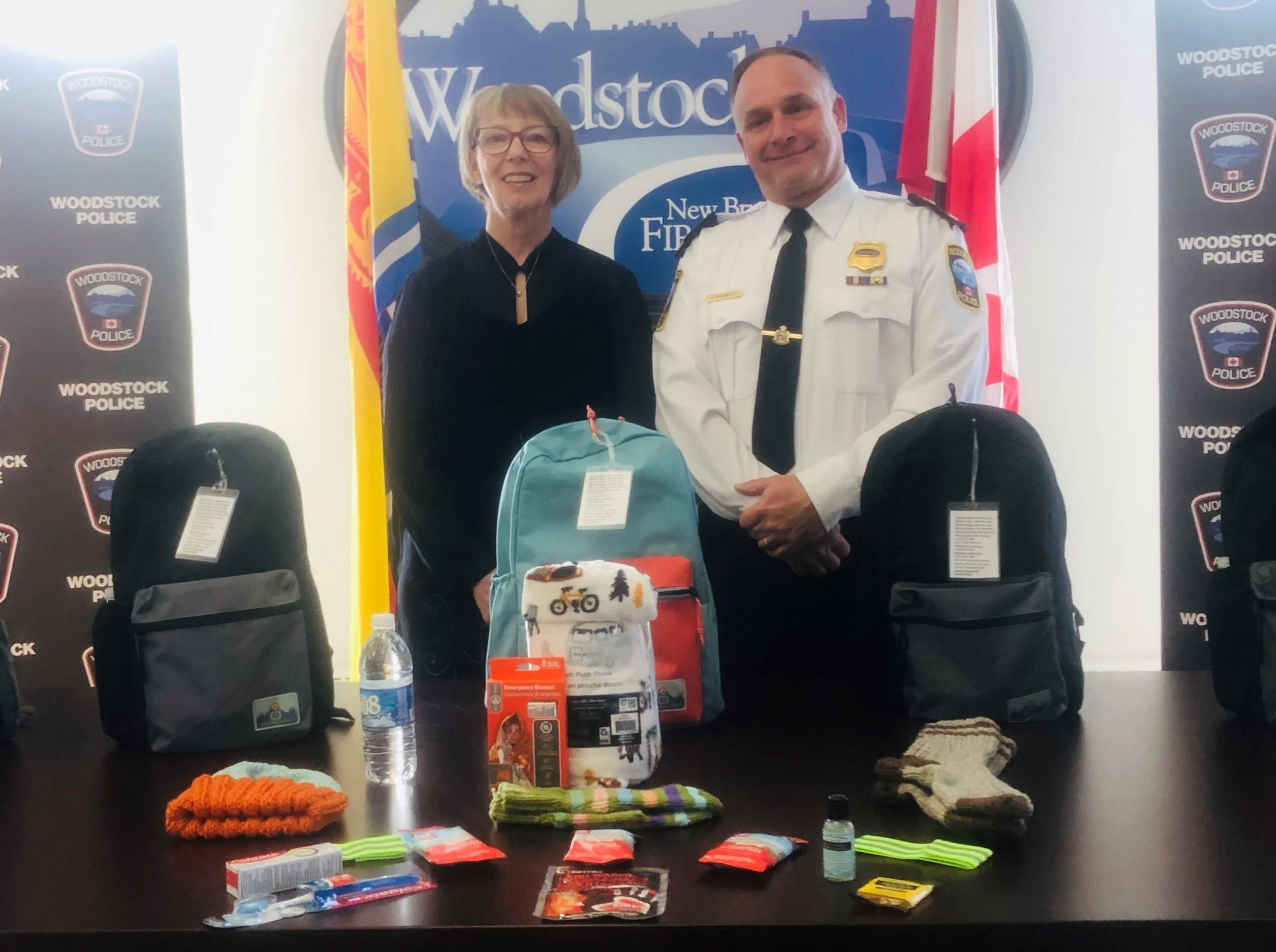 Sherrie Hunter and Deputy Chief Market Bennett display the backpacks and contents for the innovative Woodstock Police Force program to help the homeless, transient and others facing personal challenges in the town. (Jim Dumville photo)
