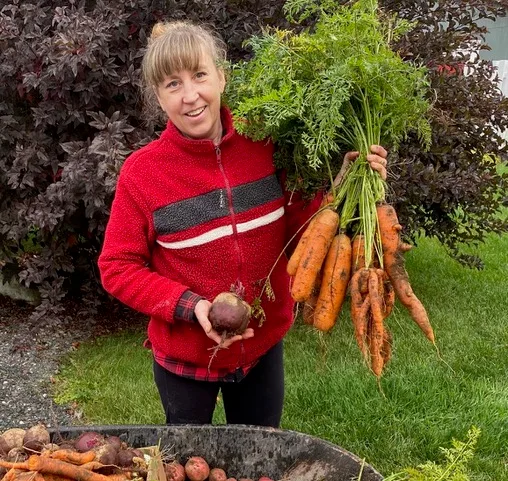 Michelle showing off her gigantic carrots she harvested last year. (Submitted photo)